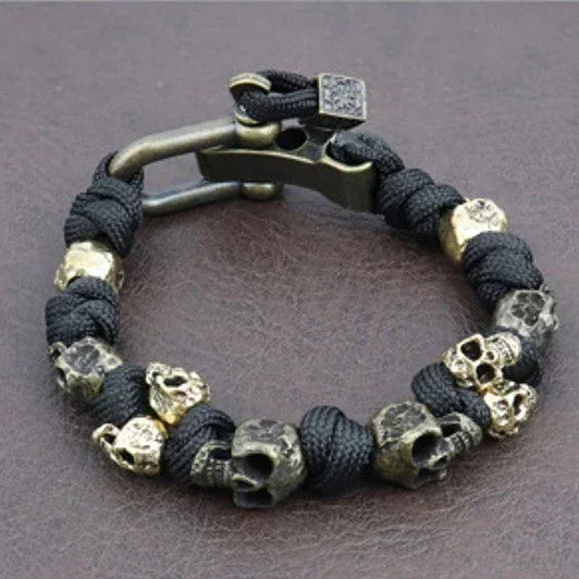 Black rope bracelet with metallic skull beads, industrial clasp, edgy streetwear style