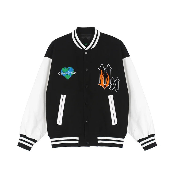 Black and white varsity jacket with bold patches, striped cuffs, and relaxed fit streetwear style