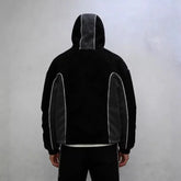 Back view of a black and grey fleece hoodie with contrast piping, relaxed fit streetwear style