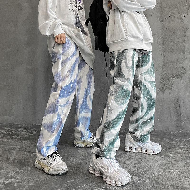 Oversized graphic sweatshirts with loose fit, abstract patterned baggy jeans, and chunky sneakers