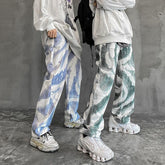 Oversized graphic sweatshirts with loose fit, abstract patterned baggy jeans, and chunky sneakers