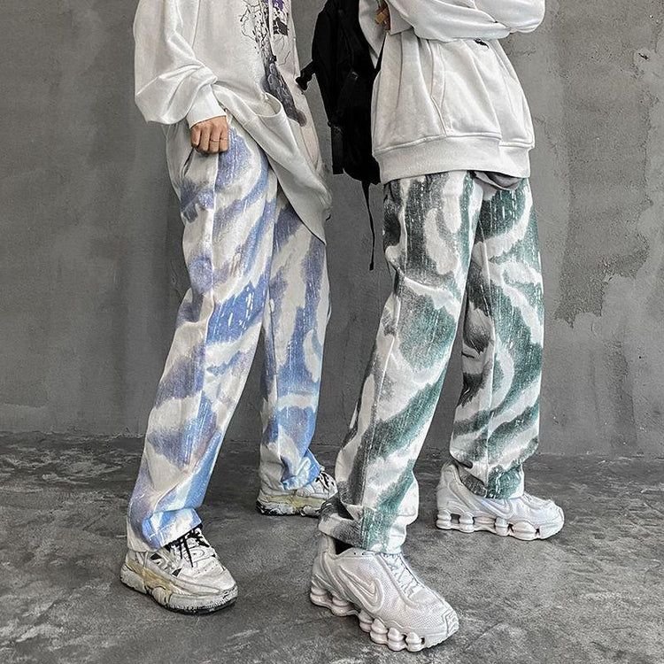 Oversized graphic sweatshirts with loose fit, abstract patterned baggy jeans, and chunky sneakers