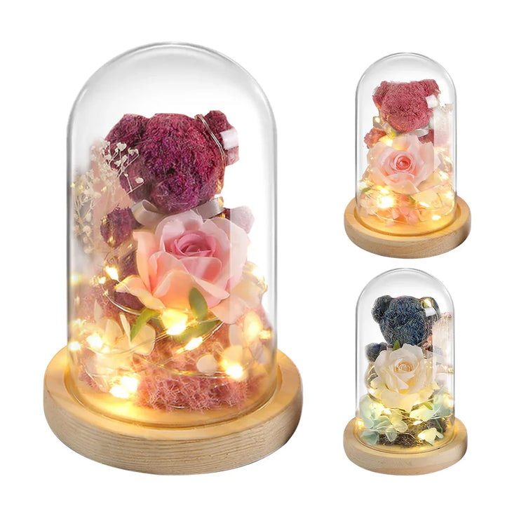 Glass dome with preserved flower bear, LED fairy lights, and roses on wooden base