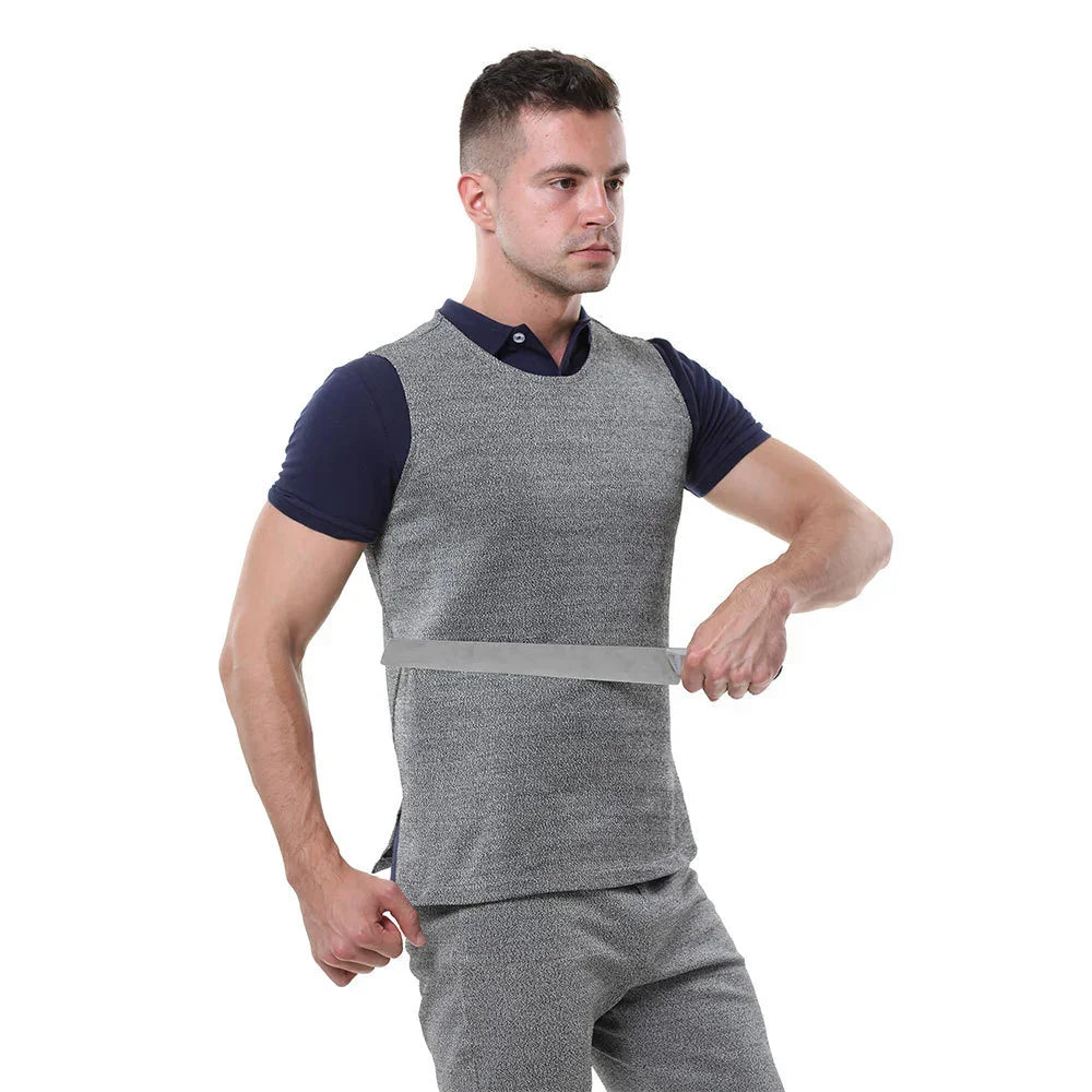 Man wearing a grey, fitted, sleeveless streetwear vest over a navy polo, measuring chest with tape