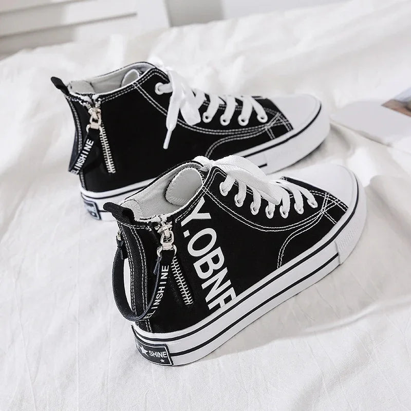 Black canvas high-top sneakers with white laces, chunky sole, and zipper detail