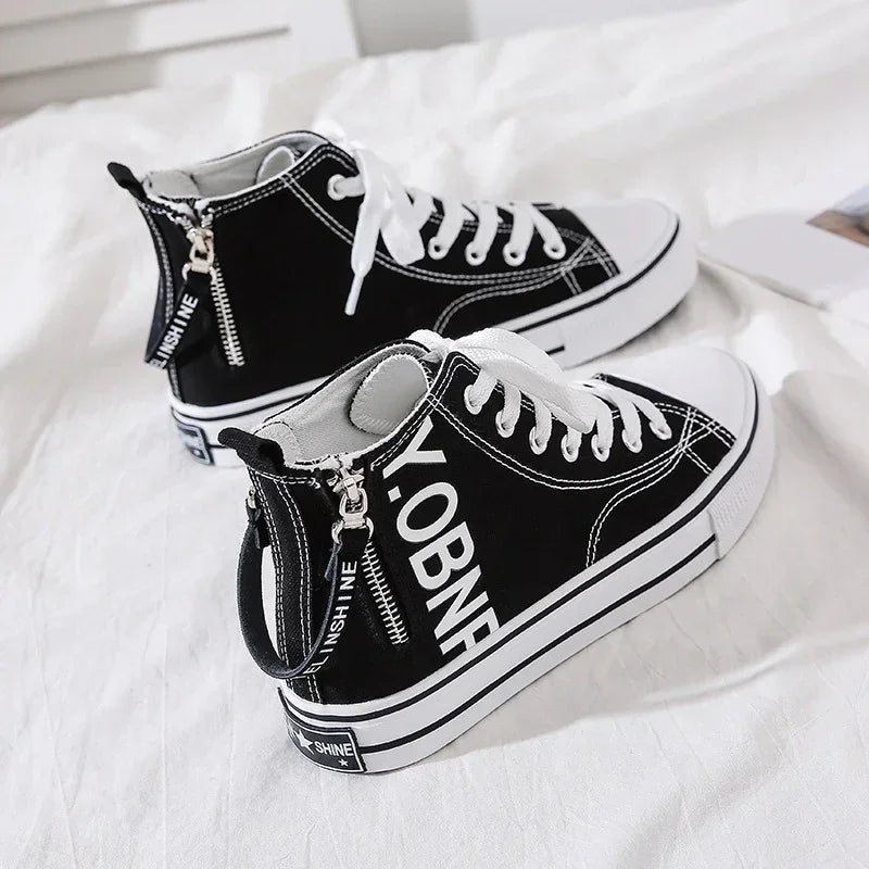 Black canvas high-top sneakers with white laces, chunky sole, and zipper detail