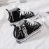 Black canvas high-top sneakers with white laces, chunky sole, and zipper detail