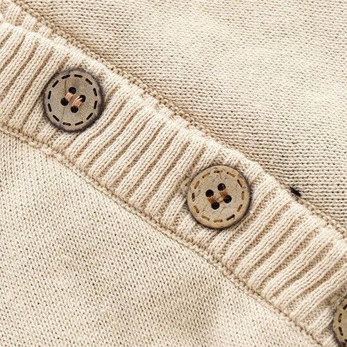 Beige knitted sweater with ribbed trim and brown wooden buttons, close-up on texture and details.