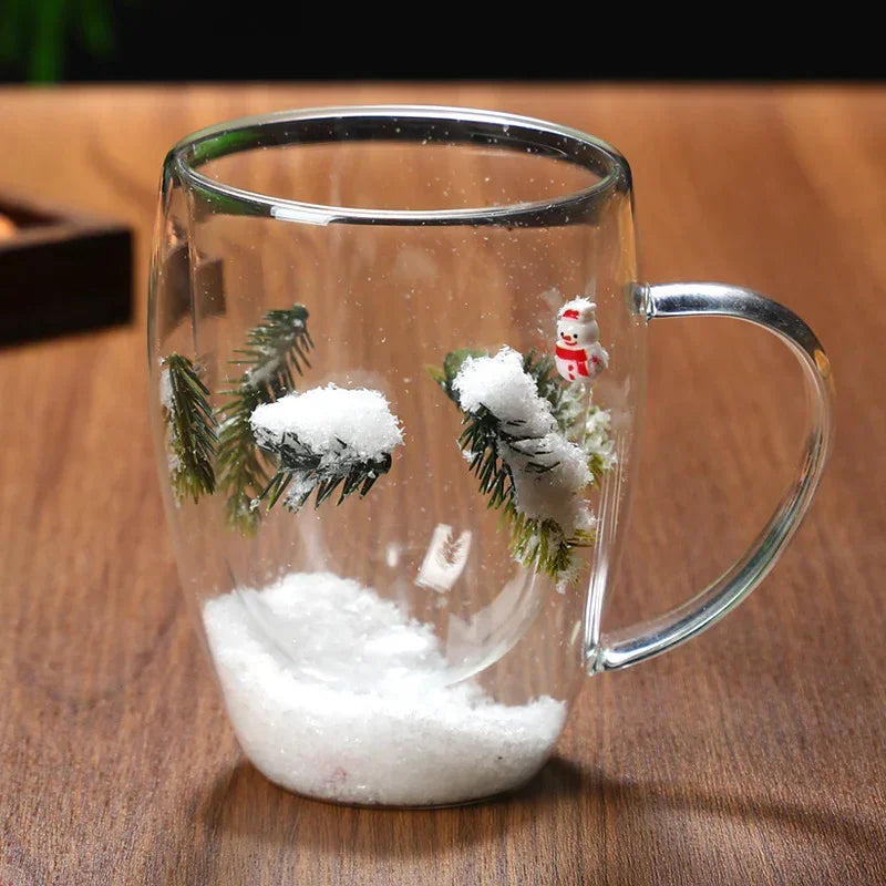 Clear glass mug with winter snow scene, pine branches, artificial snow, and snowman inside