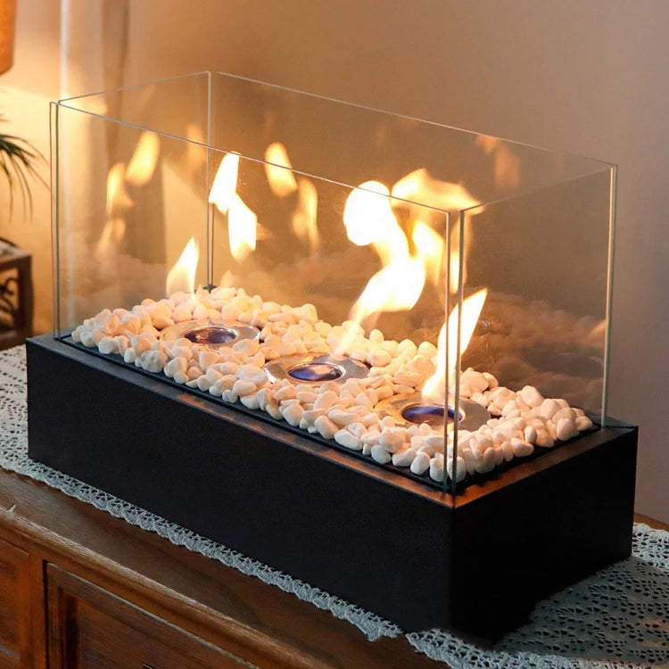 Modern tabletop glass fire pit with white decorative pebbles and black rectangular base