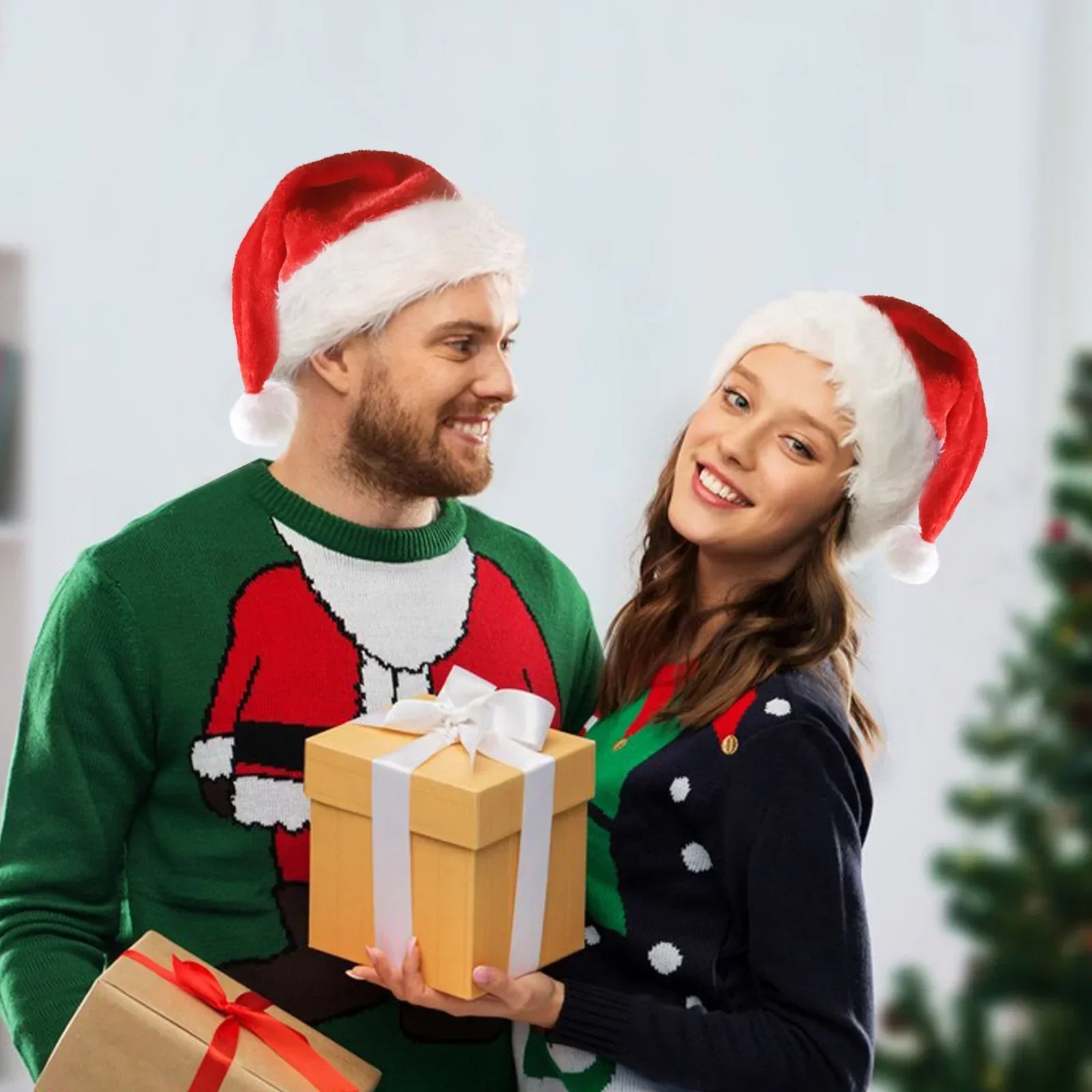 Couple in festive Christmas sweaters and Santa hats holding gift boxes, cozy holiday style