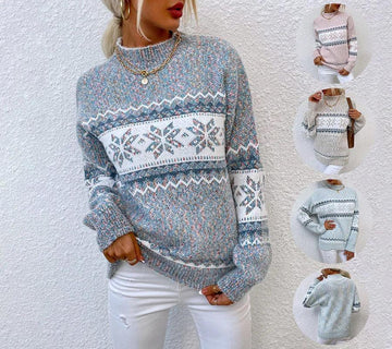 Women’s loose fit knit sweater featuring a blue and white snowflake pattern, long sleeves, crew neck, and soft textured material paired with white jeans.