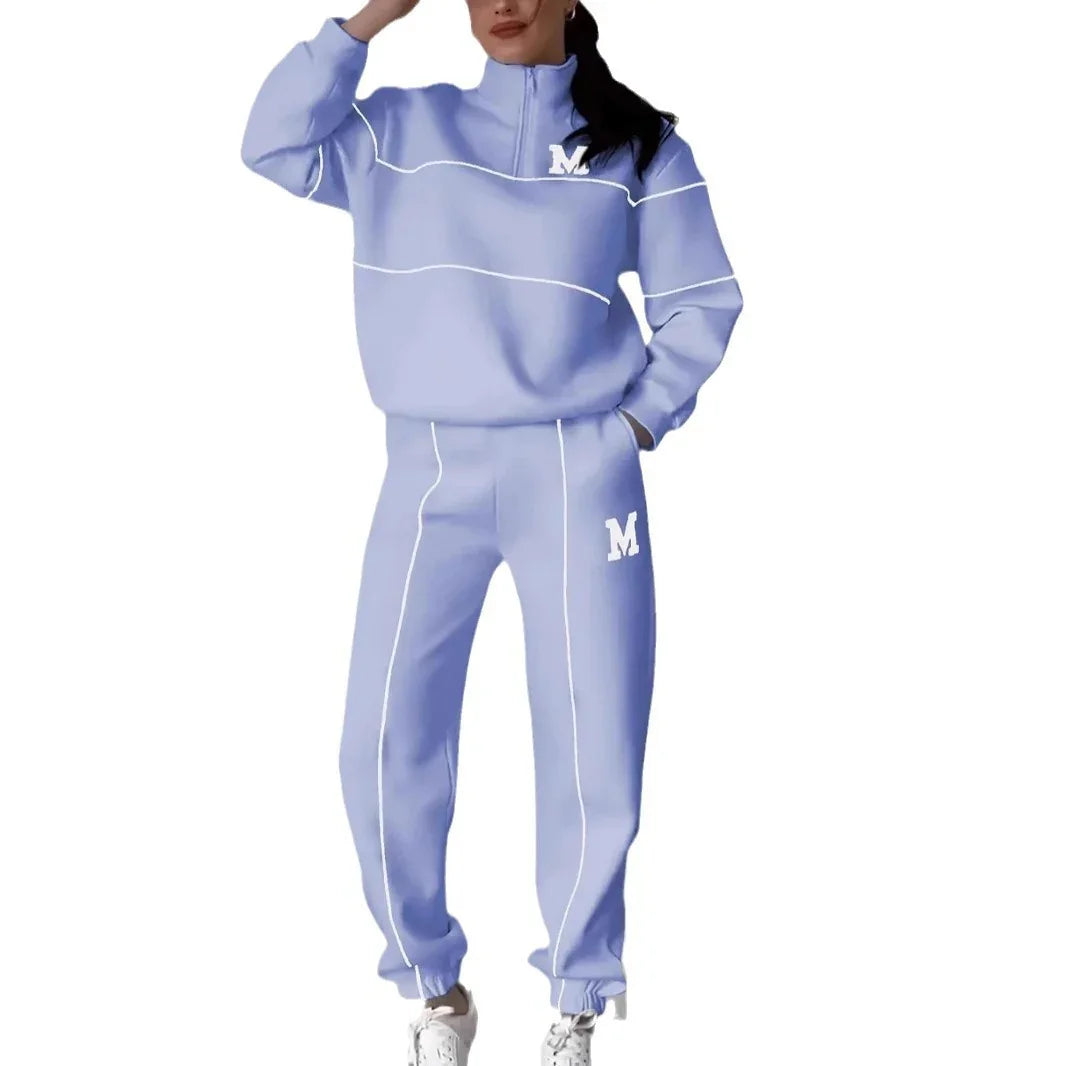 Woman wearing loose fit light purple tracksuit set with white piping and letter M detail