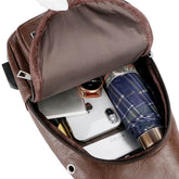 USB portable charging chest bag open showing storage compartments with phone, wallet, and umbrella inside