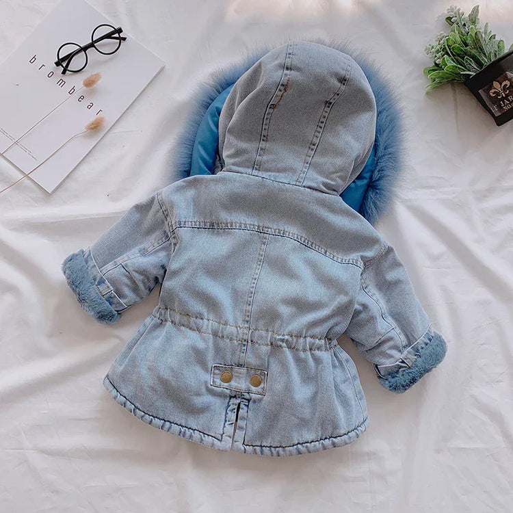 Light blue denim hooded jacket with faux fur trim and rolled cuffs, laid flat on white fabric.