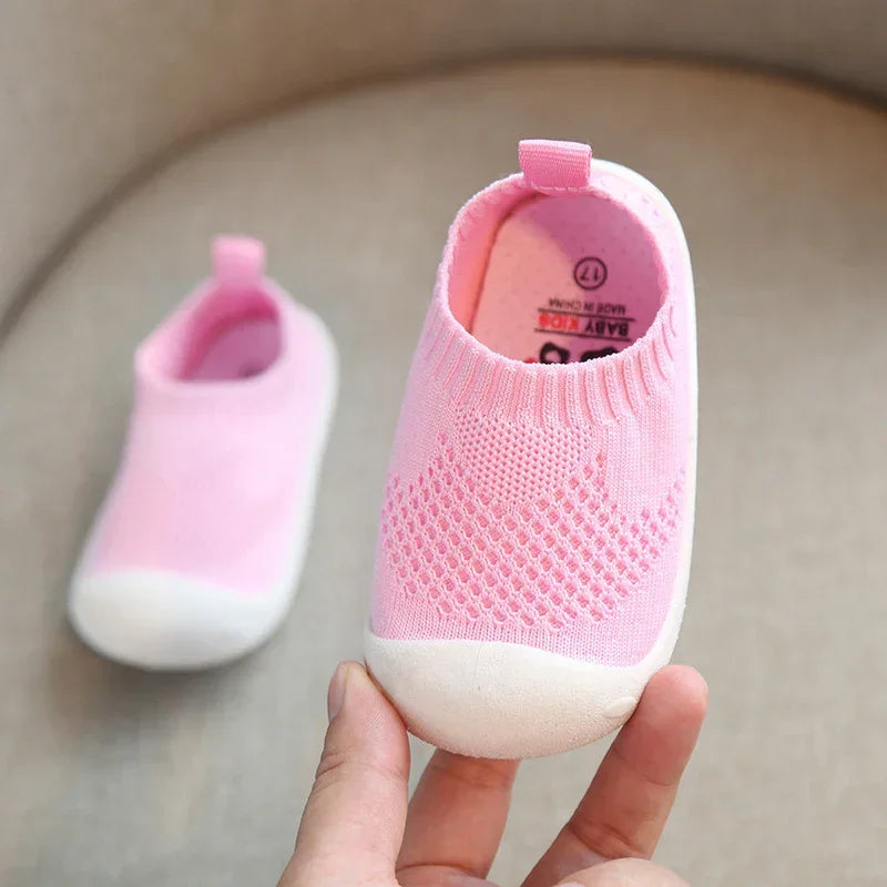 Pink slip-on baby shoes with knit mesh upper and white rubber toe, breathable and soft fit