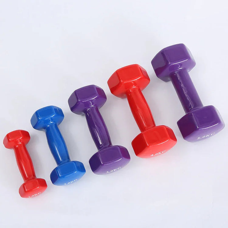 Set of colorful neoprene dumbbells in red, blue, and purple on white background