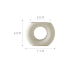 Minimalist white ceramic vase with circular open center, 14cm tall, 17cm wide, 13cm deep.
