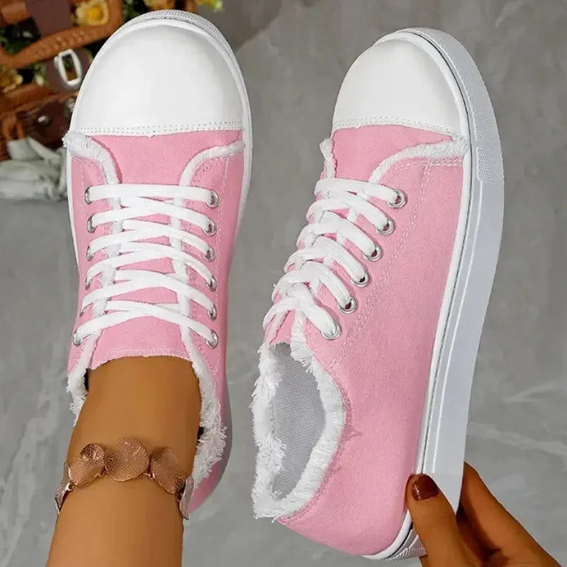 Light pink canvas sneakers with white rubber soles and laces, featuring a casual fit