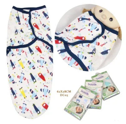 White baby swaddle with colorful rocket print, navy trim, soft cotton, snug fit.