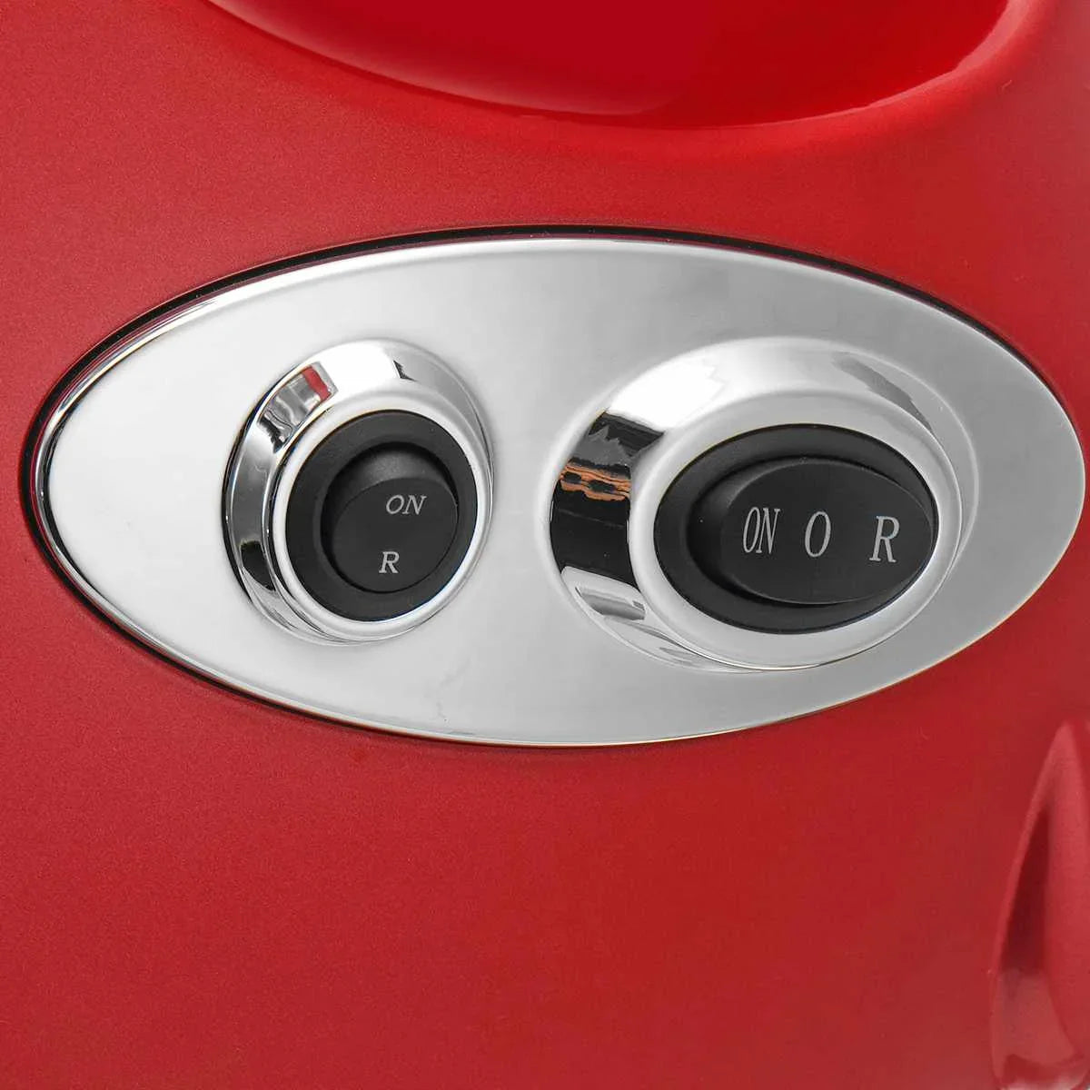 Close-up of black and chrome control switches on red glossy surface, modern appliance panel