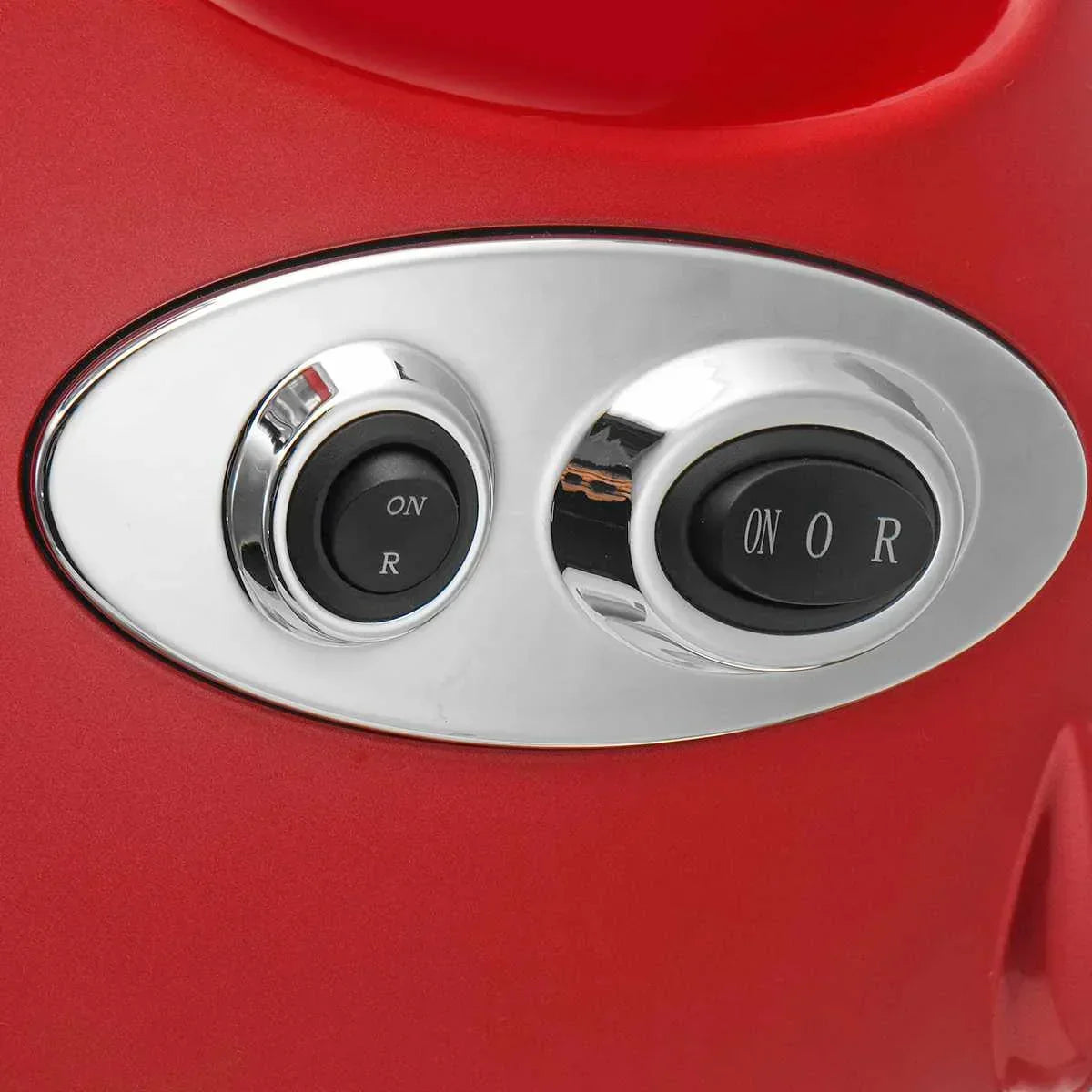 Close-up of black and chrome control switches on red glossy surface, modern appliance panel