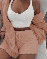 Woman wearing a fuzzy white crop top with peach textured shorts and a matching cardigan