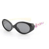 Black oval sunglasses with white arms and pink cartoon accents, glossy plastic frame