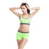 Woman modeling neon green sports bra and shorts set with grey trim, fitted activewear style