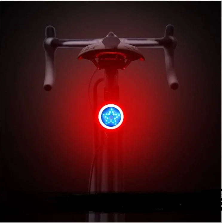 Bicycle rear view with illuminated red and blue LED tail light in a dark setting
