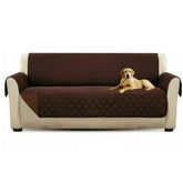 Brown quilted sofa cover on beige couch with dog, protective pet-friendly furniture slipcover