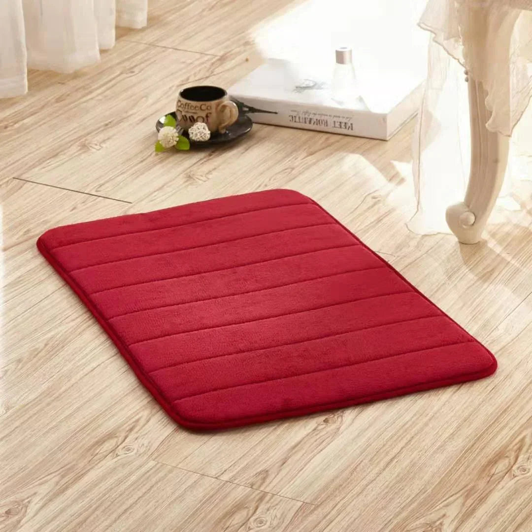 Plush red rectangular floor mat with a soft textured surface, displayed on wood flooring