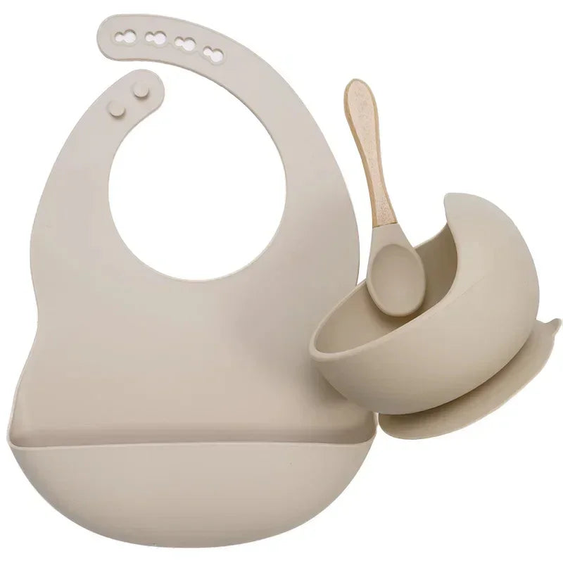 Beige silicone bib, bowl, and spoon set with a minimalist, modern design, soft easy-clean material.