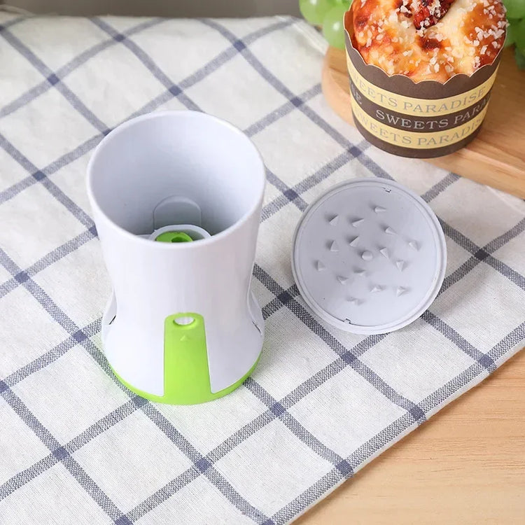 White and green plastic kitchen grater with removable lid on checkered cloth