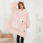 Woman wearing oversized pink fleece hoodie blanket with kangaroo pocket, relaxed fit