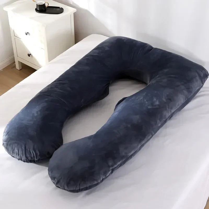 Large U-shaped dark grey velvet body pillow on a bed, ergonomic and plush for comfort.