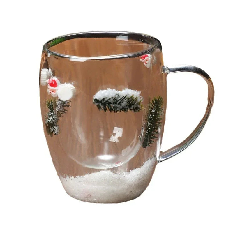 Clear glass mug with festive winter designs, fake snow, evergreen branches, and Santa figures