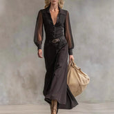 Woman wearing black sheer long sleeve button-up shirt and wide-leg pants, carrying tan bag