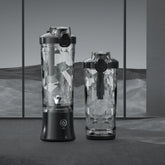 Two clear geometric-textured bottles with black lids, modern design on gray background
