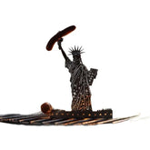 Metal silhouette of Statue of Liberty holding a sausage, white background, novelty decor