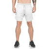 White drawstring shorts with black logo, relaxed fit, layered design, paired with black sneakers