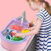 Girl wearing a white and navy striped cotton dress playing with a toy sink and dishes.