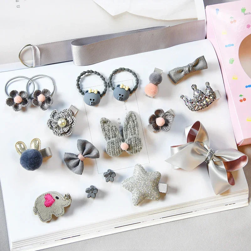 Assorted gray and silver hair clips and bows with plush, glitter, and knit textures on display.