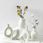Minimalist white ceramic vases with matte finish, featuring dried flowers and cotton stems