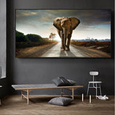 Modern minimalist living room with a large wall art featuring an elephant on a road, neutral decor, gray seating, and wooden flooring.