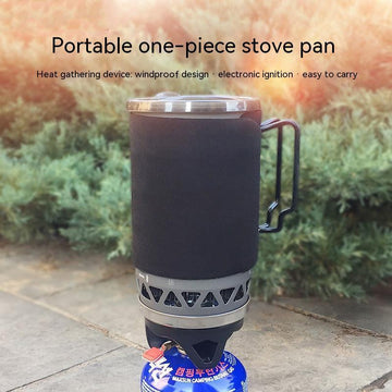 Black insulated portable camping stove pan with metal handle outdoors on stone surface
