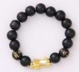 Black beaded bracelet with gold charm and engraved details, modern streetwear accessory