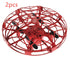Red hand-controlled toy drone with protective cage design and black propellers