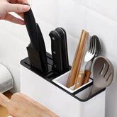 Modern kitchen utensil holder with black knives, wooden chopsticks, fork, and slotted spoon