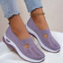 Light purple knit slip-on sneakers with cutout detail and thick white sole, worn with jeans